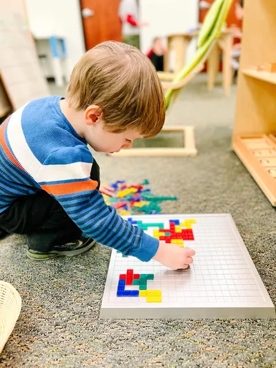 Young boy arranging colorful blocks in The Spark Studio